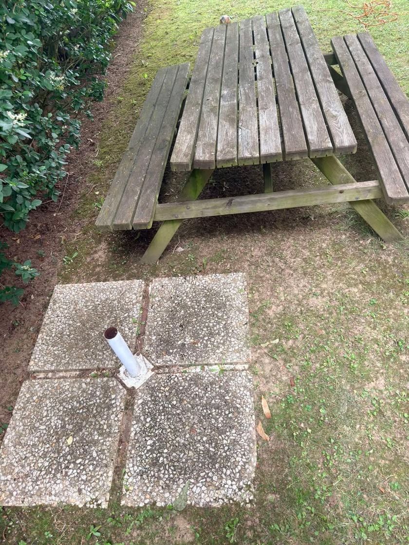 Table de jardin en bois grisée par les intempéries et dalles verdies, avant nettoyage